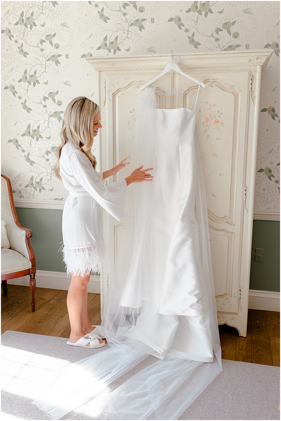 Bride touching pranovias wedding dress in historic vintage bedroom