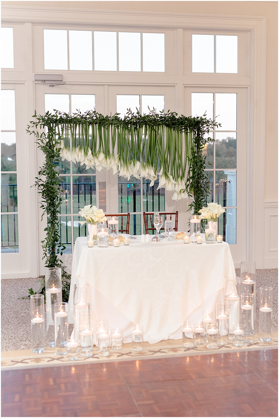 reception head table decorated with unique Calle lily flowers and romantic candles