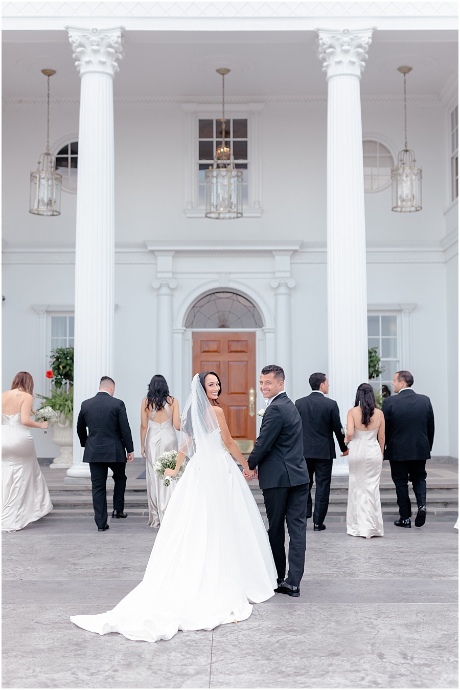 bride and groom portraits in front of Trump National Bedminster with bridal party